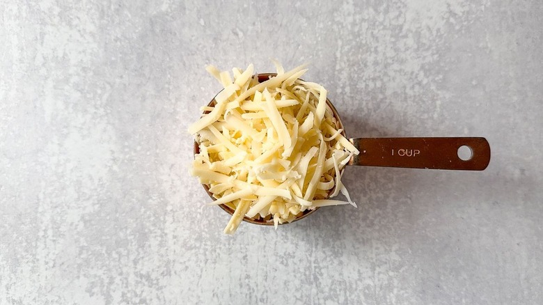1-cup measure filled with shredded gruyere cheese