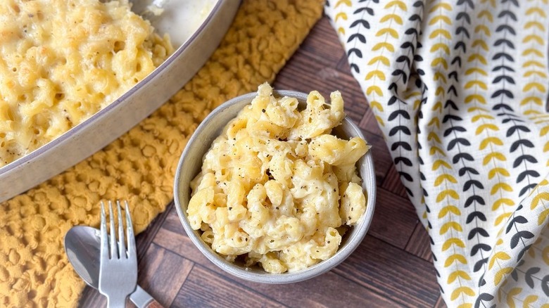 3-ingredient baked mac & cheese in serving dish and bowl on table with napkin