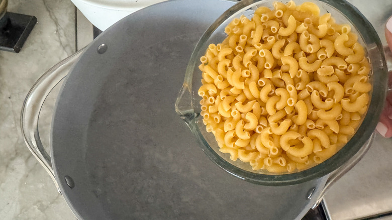 adding macaroni to pot