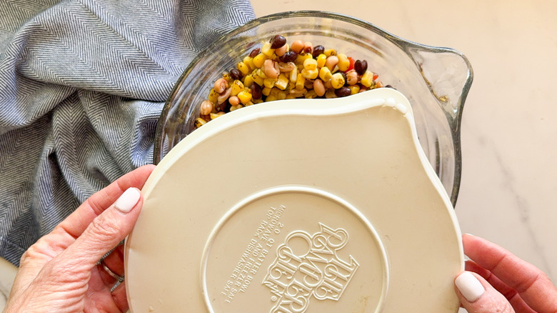 hands covering bowl with lid