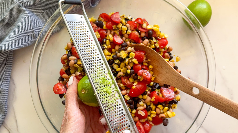 hands zesting limes over bowl