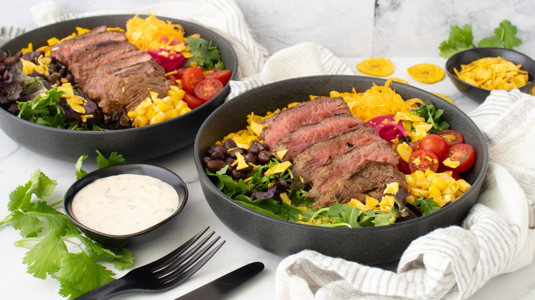 Steak taco bowls next to bowl of ranch