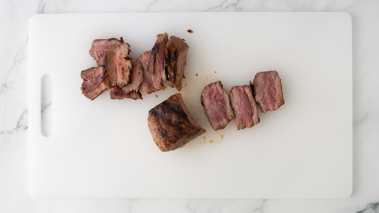 Sliced steak on cutting board