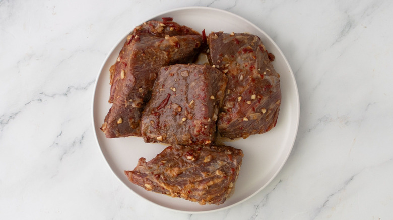Chunks of marinated steak on plate