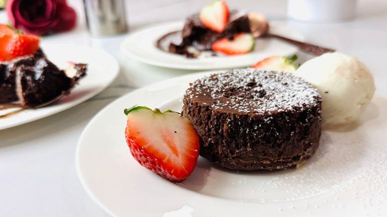Chocolate lava cake on plate with ice cream and strawberry