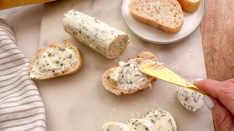 hand spreading butter on bread