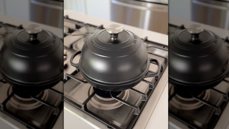 Licorice Le Creuset pan with lid on stove top.