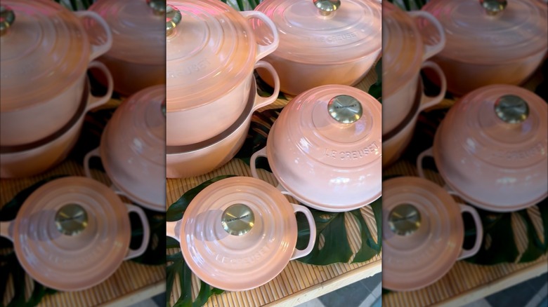 Pêche colored Le Creuset pots and pans with lids.