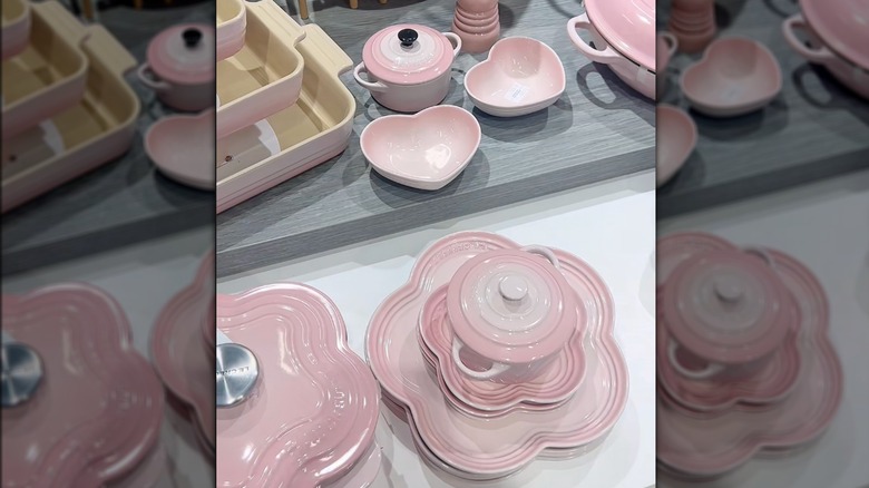 Shell pink Le Creuset items displayed on counter.