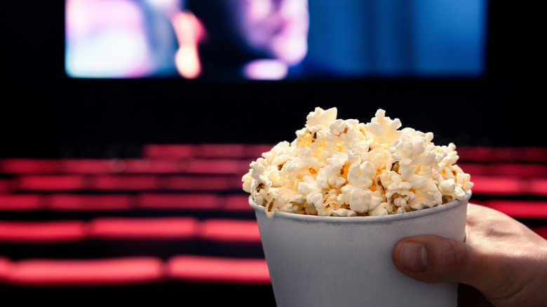 A bucket of popcorn in an empty movie theater