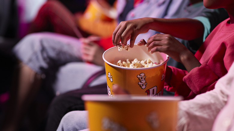 People eating popcorn at a movie theater