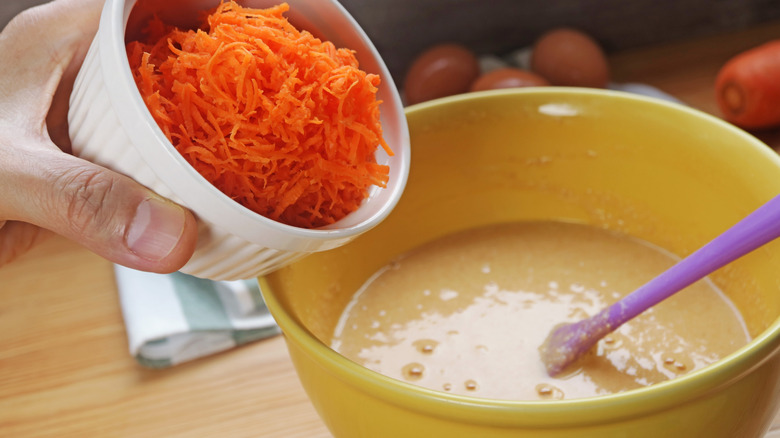 adding fresh grated carrots to carrot cake batter
