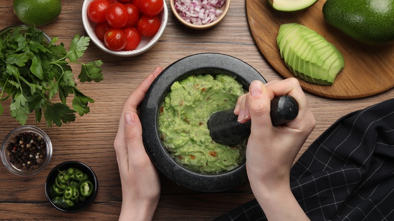 person preparing guacamole