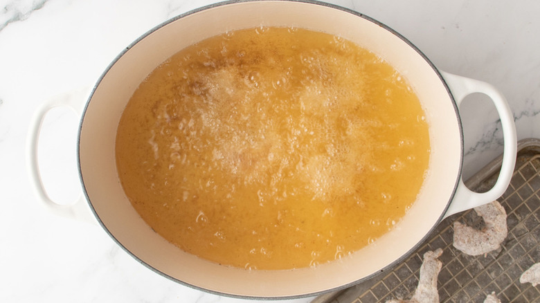 Shrimp frying in large pot of oil