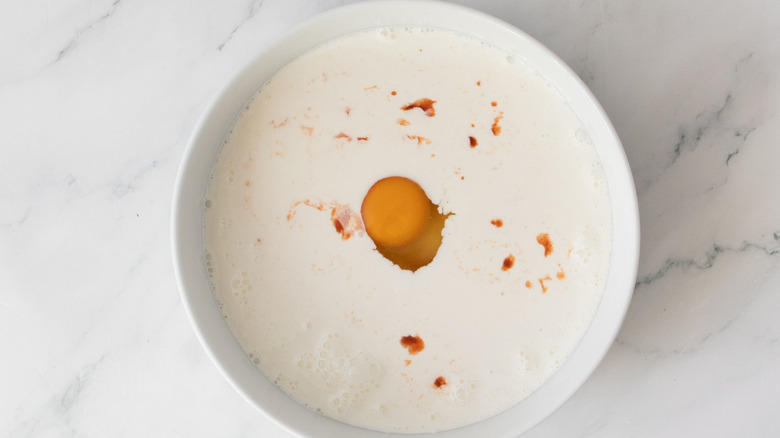 Milk, egg, and hot sauce in bowl