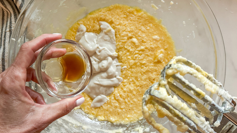 hand adding vanilla to bowl with pancake bread batter