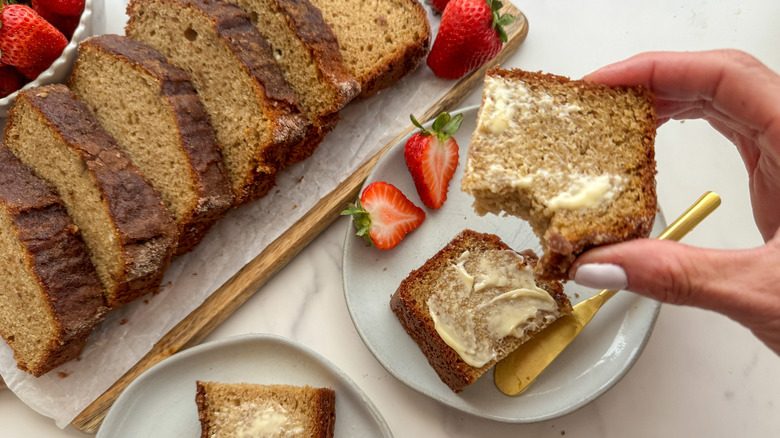 hand holding piece of pancake bread next to sliced pieces of bread