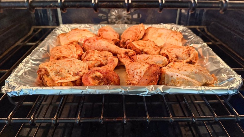 Honey bourbon BBQ chicken on foil-lined baking pan in oven