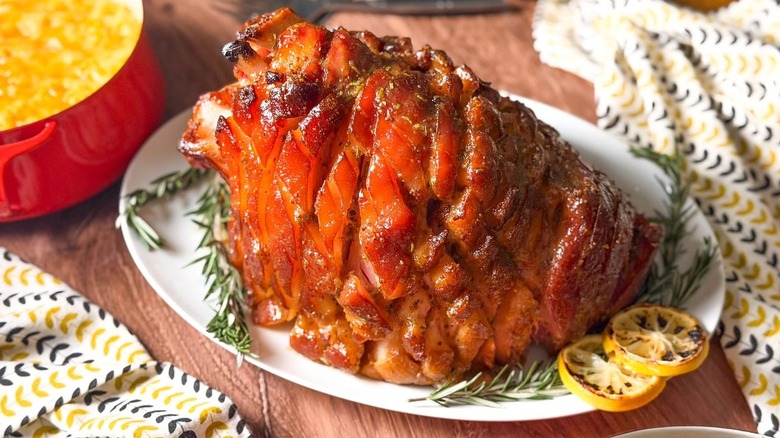 Miso and maple-glazed ham on serving plater with lemon wheels and rosemary branches