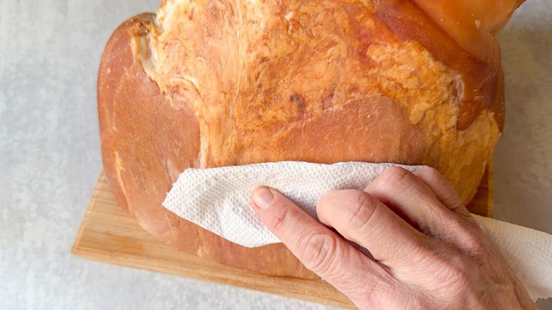 Blotting ham dry with paper towel