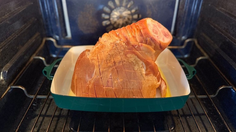 Bone-in ham in roasting pan in oven