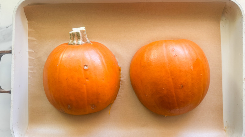 pumpkin halves on baking sheet