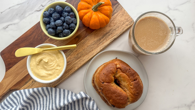 pumpkin cream cheese on board next to bagel and blueberries