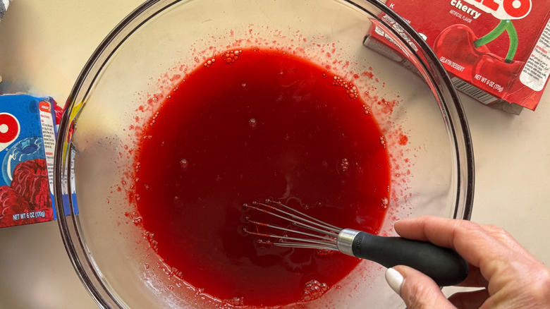 hand stirring red mixture