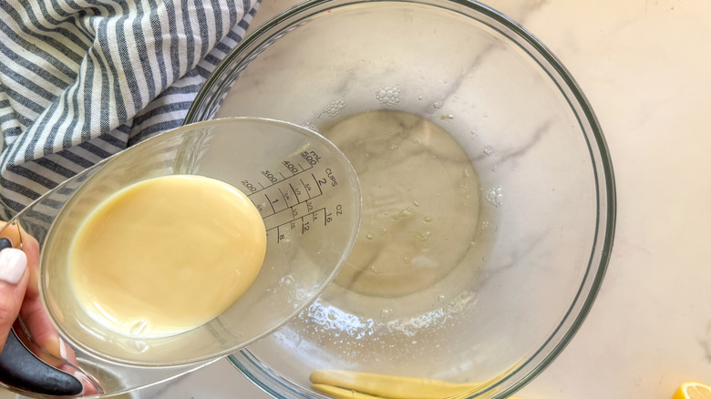 hand adding the condensed milk