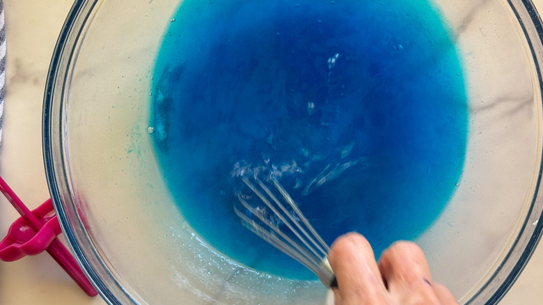 hand stirring blue mixture