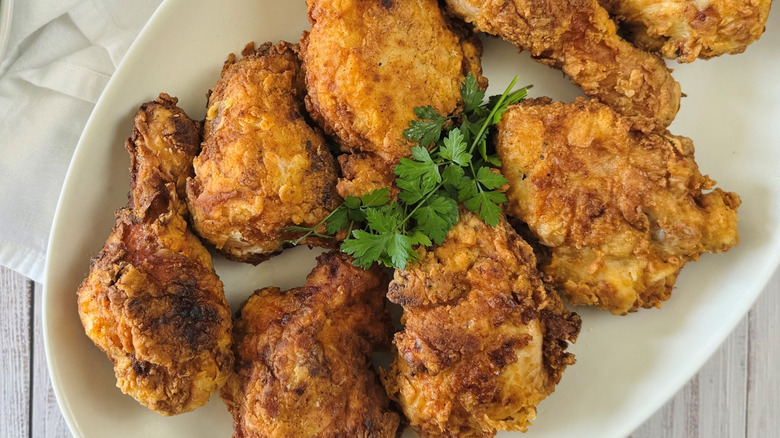 Fried chicken on serving platter with herbs