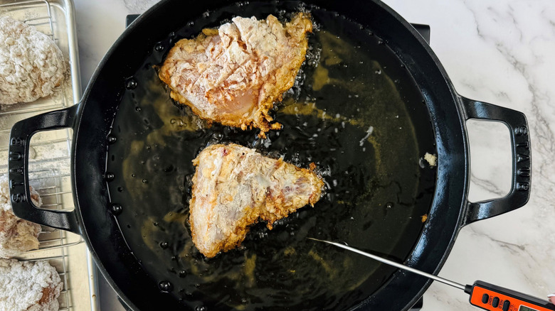 Chicken breasts frying in large skillet