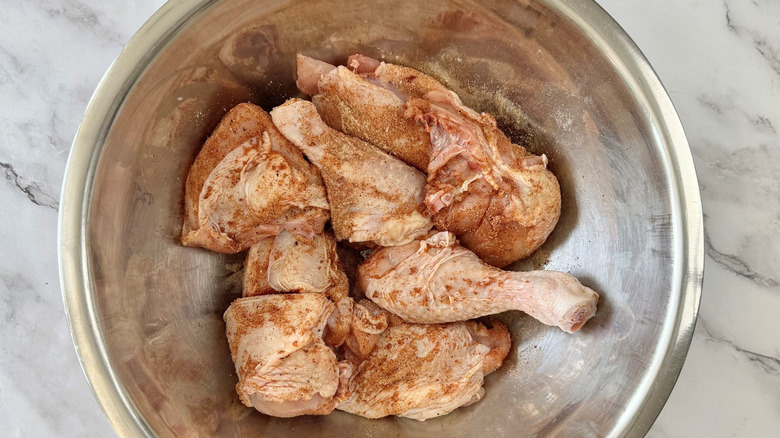 Raw chicken pieces coated in seasoning
