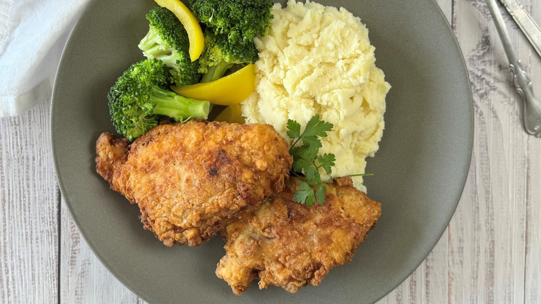 Fried chicken on plate with mashed potatoes and broccoli