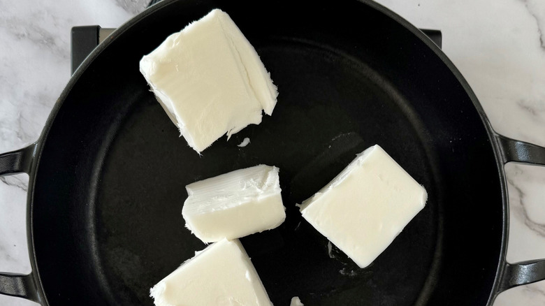 Lard pieces in large skillet
