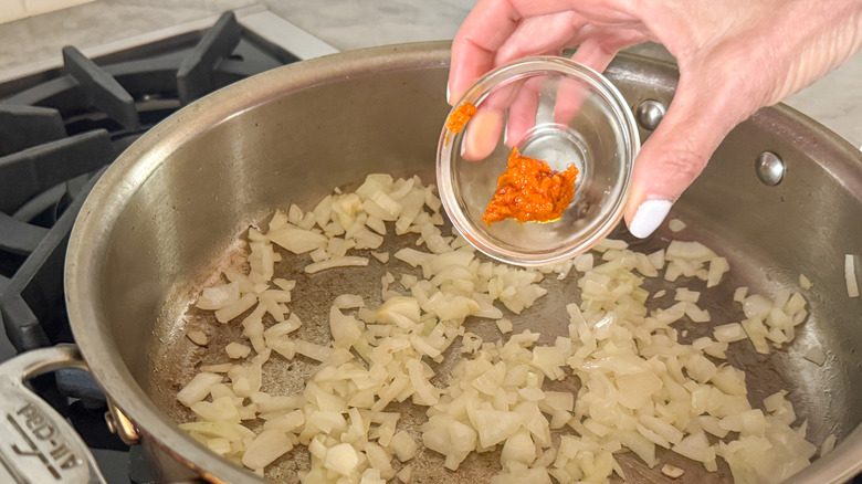 hand adding calabrian chile paste