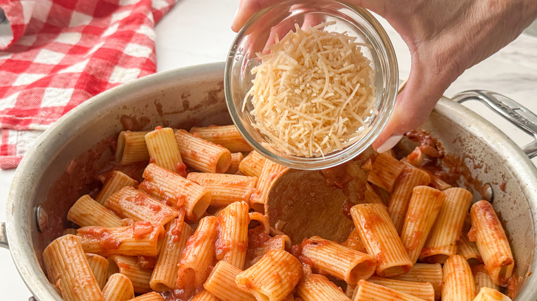 hand adding parmesan