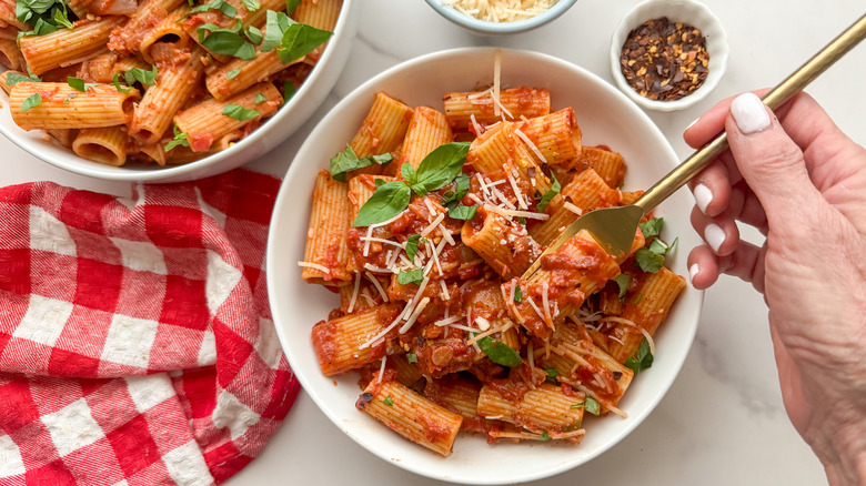 hand with fork in pasta