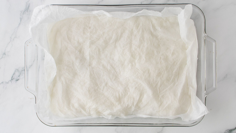 Casserole dish with layer of paper towels over it