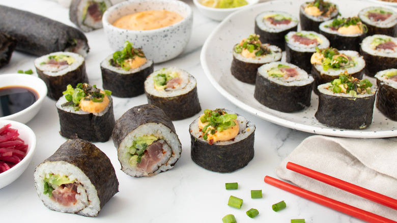 Spicy tuna sushi roll pieces on plate and countertop