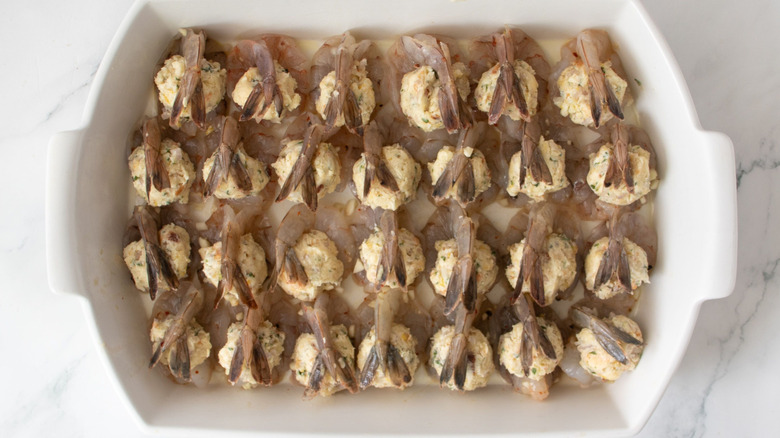 Stuffed raw shrimp arranged in casserole dish