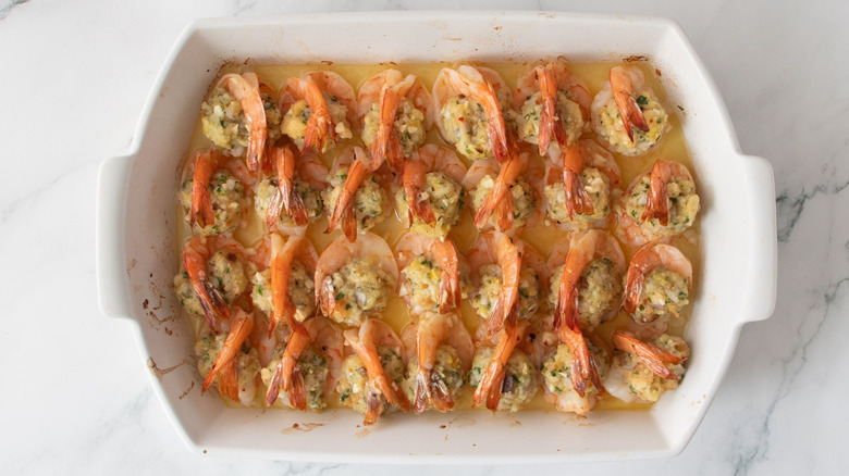 Cooked stuffed shrimp arranged in casserole dish