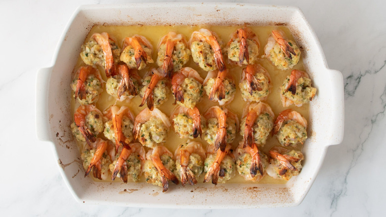 Cooked stuffed shrimp arranged in casserole dish