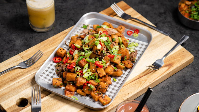Loaded tater tot nachos are displayed on a tray.