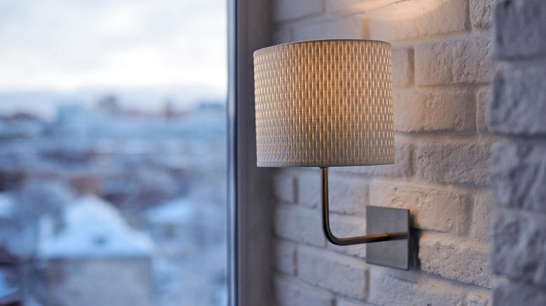 brass wall sconce with a natural linen shade