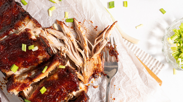 BBQ baby back ribs with pieces pulled apart with a fork