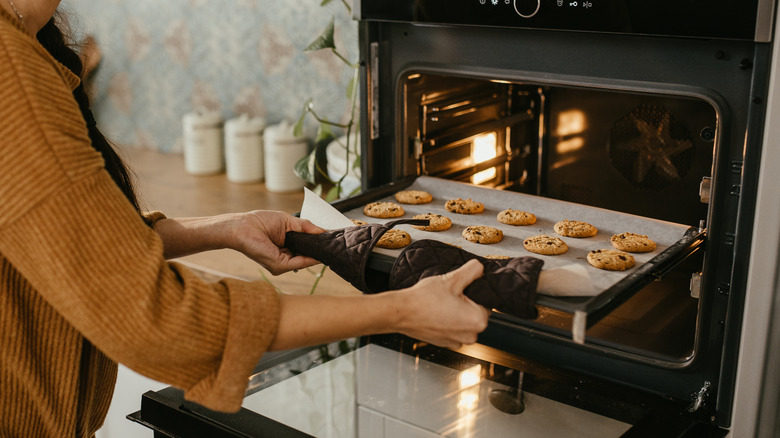 Person taking cookies out of the oven
