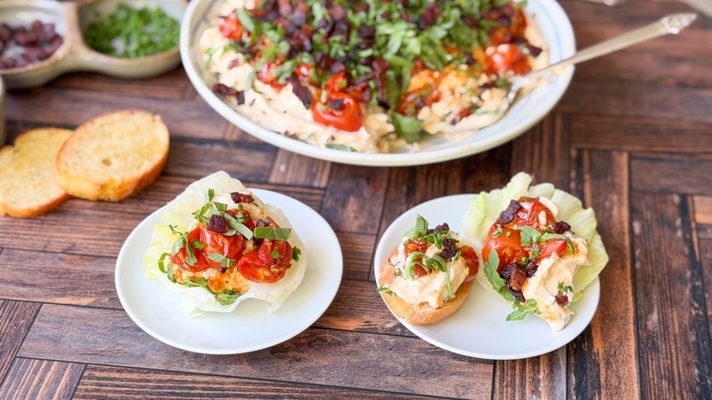Over-the-top BLT dip in lettuce cups and on toast with serving dish in background