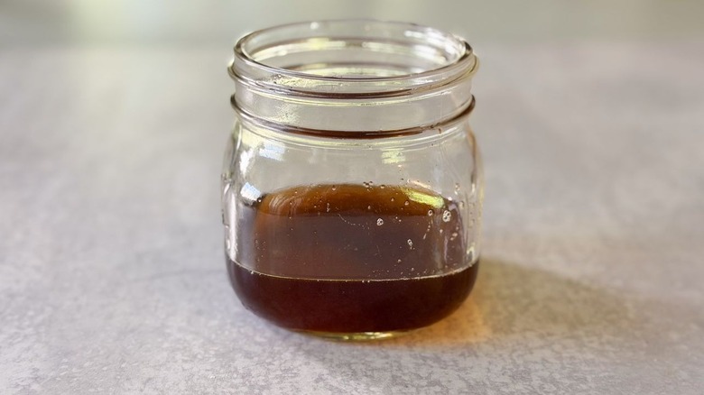 Liquid bacon brown butter in glass jar on countertop