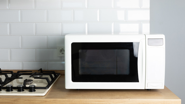 A modern white microwave on a kitchen countertop.
